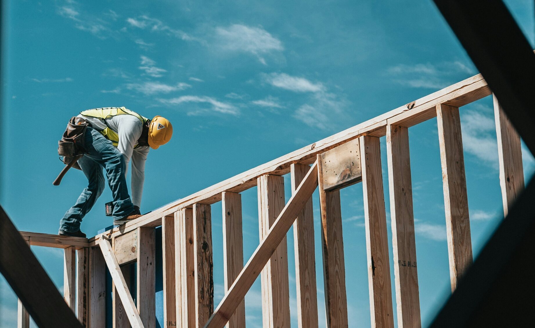 Construction worker standing on top of unfinished house