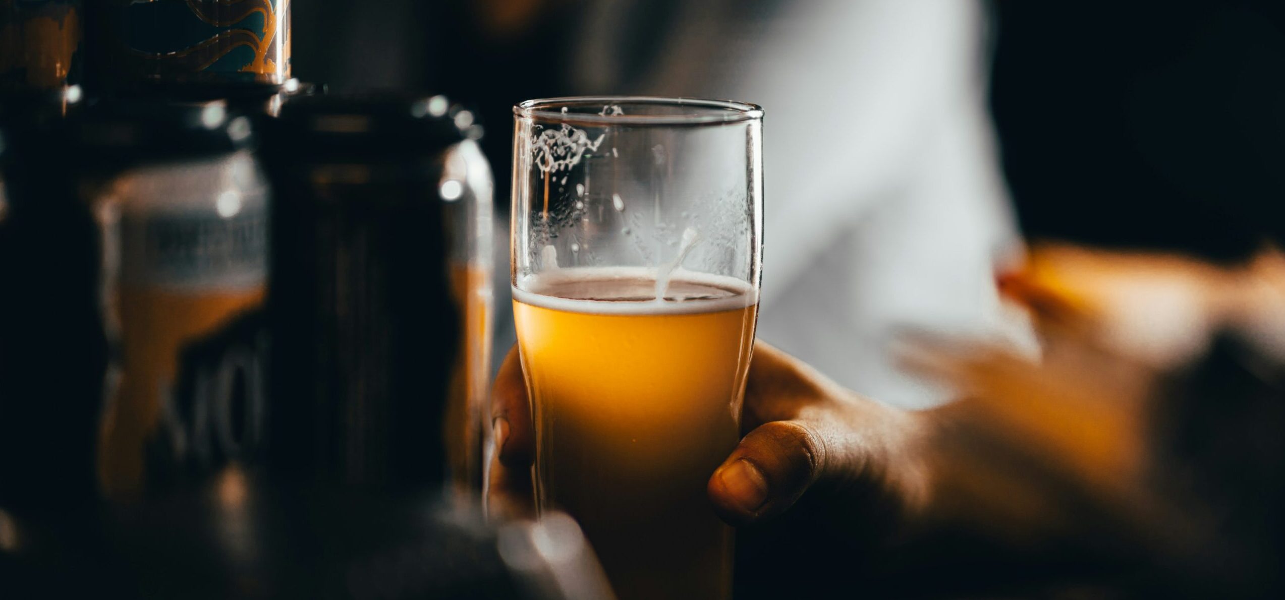 Hand holding beer in glass