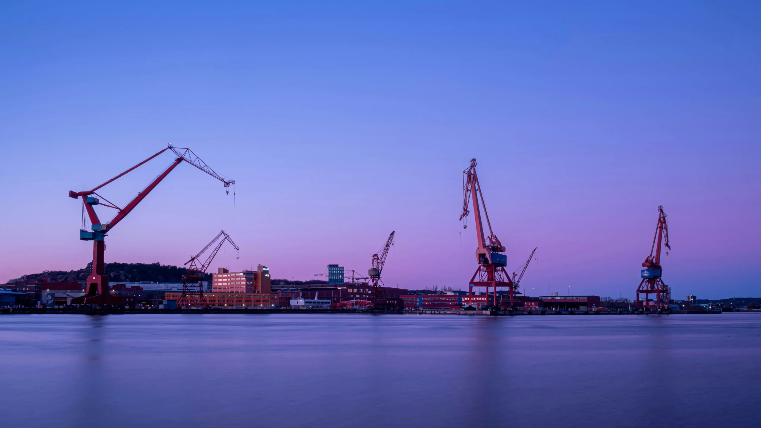 A picture depicting the three red cranes in Gothenburg taken in the evening