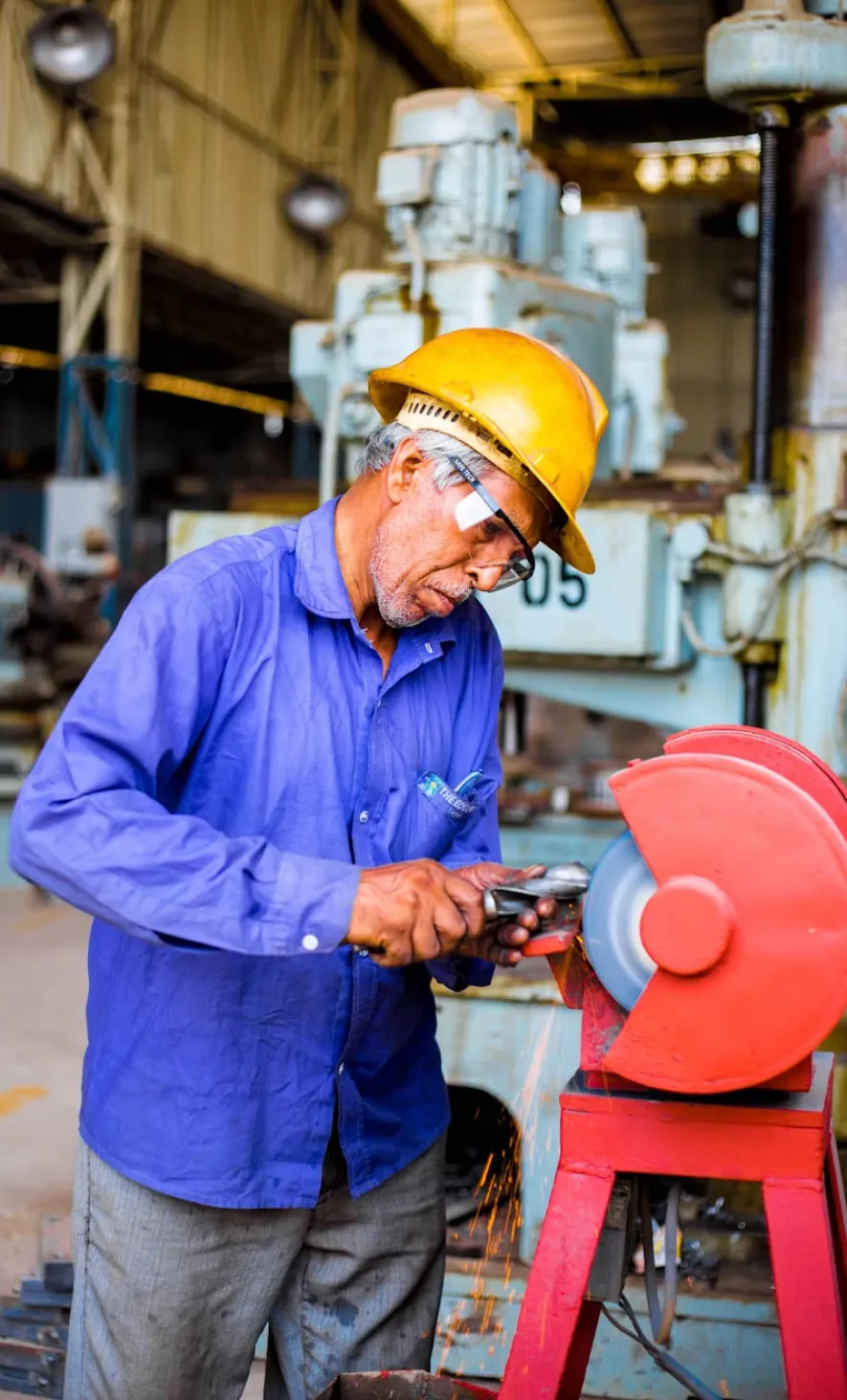 Man with blue shirt and yellow helmet is grinding