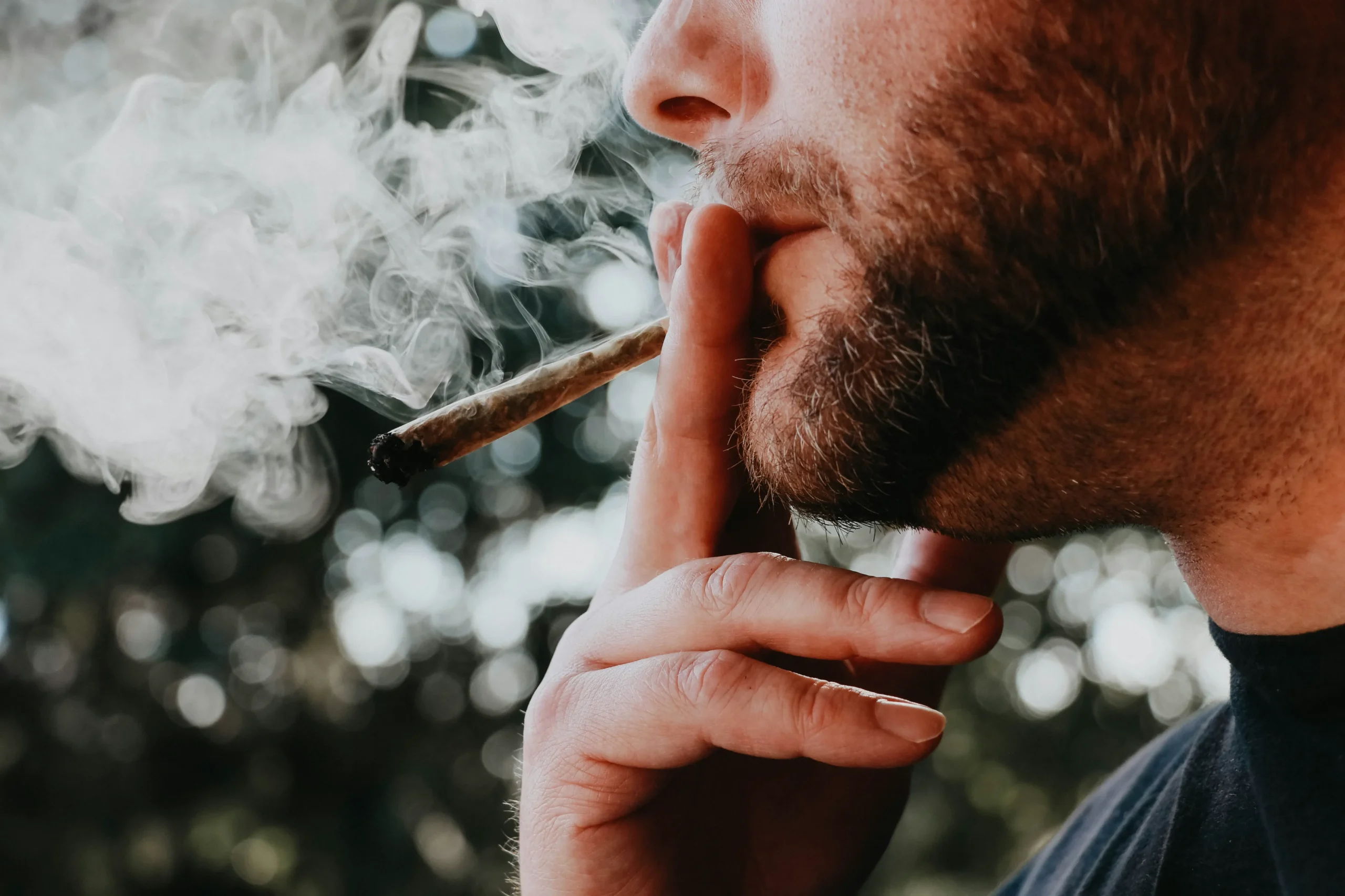 Man with beard smoking marijuana joint